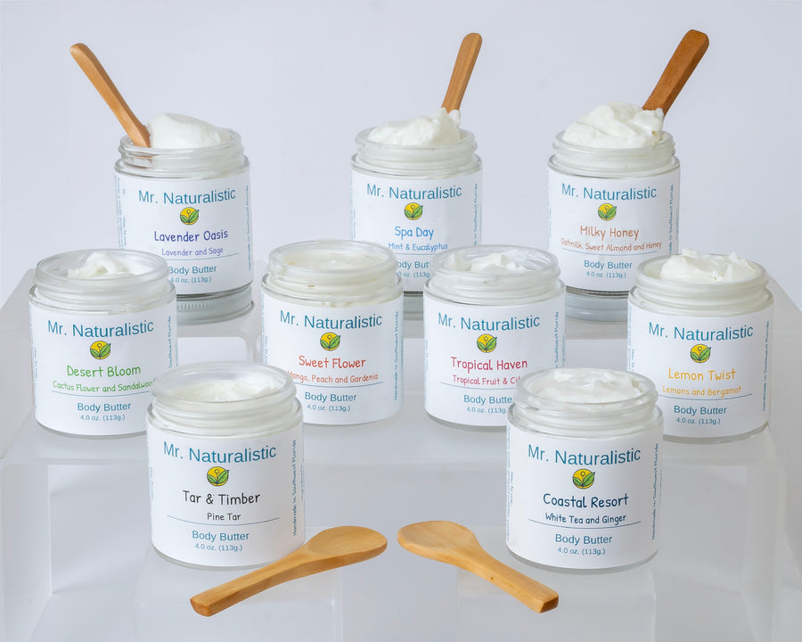 Naturalistic body butter jars in a range of scents with wooden spatulas.